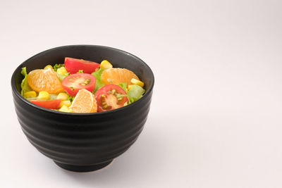 Close-up of fruits in bowl against white background