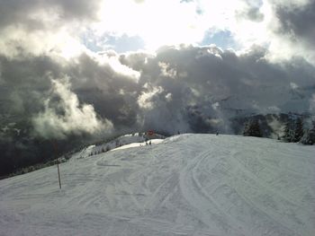 Snow covered mountain against cloudy sky