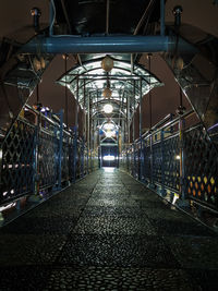 Empty illuminated walkway at night