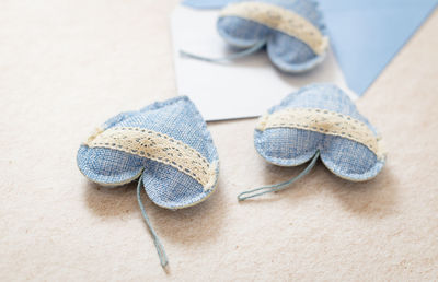 Envelope with three textile hearts falling out on a stone background.