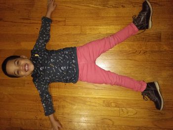 Portrait of young woman lying on hardwood floor