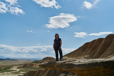 Full length of man standing on rock against sky