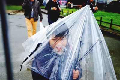 Portrait of boy seen through transparent umbrella