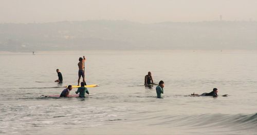 People enjoying in sea during foggy weather