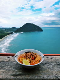 Food on table by sea against sky