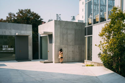 Woman by tree against sky