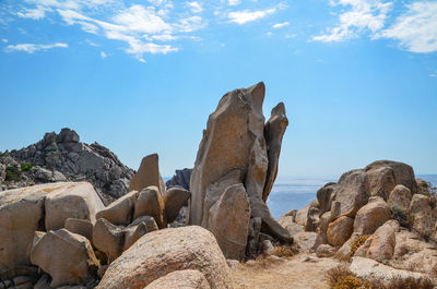 Rock formations on sea shore against sky