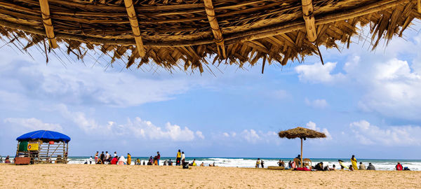 Group of people on beach against sky