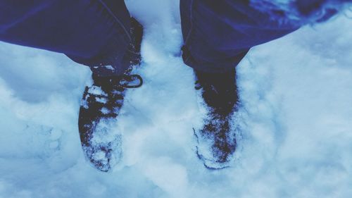 Low section of man standing in snow