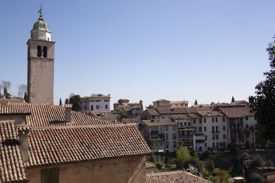 Buildings in city against clear sky