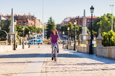 Rear view of man riding bicycle on street