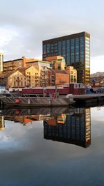 Reflection of buildings in city against sky