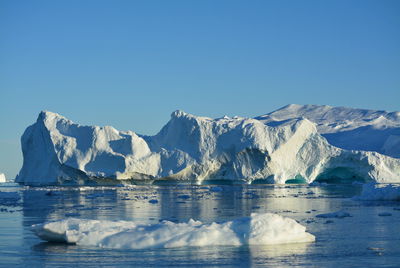 View of majestic iceberg in sea against sky