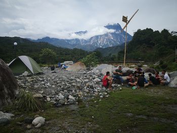 Group of people on mountain range against sky