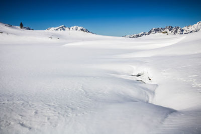 Scenic view of snow covered mountain against blue sky in alpe d'huez in french alps