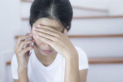 Close-up portrait of a woman covering face