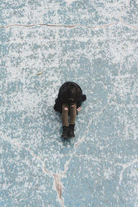 Full length of woman sitting on cracked footpath