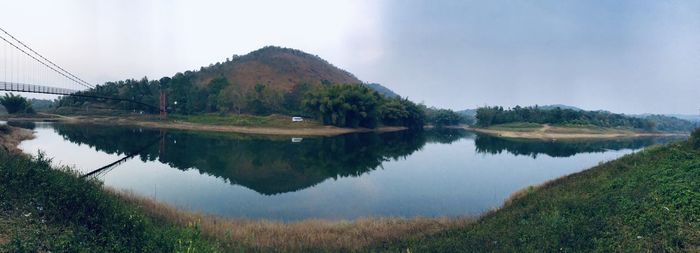 Scenic view of lake by trees against sky