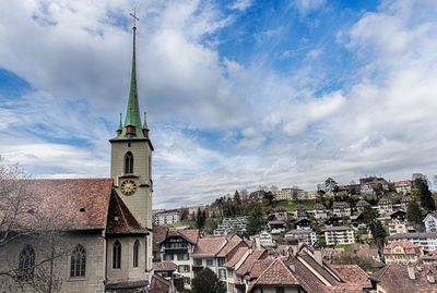 Buildings in city against cloudy sky