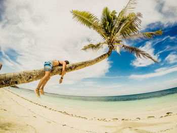 Low angle view of woman standing on beach against sky