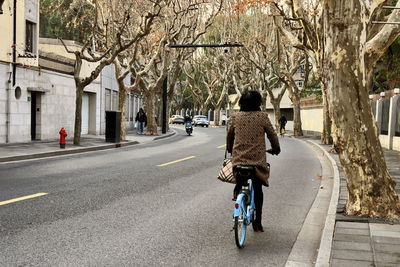 A woman rides her bike on wukang road in shanghai, china