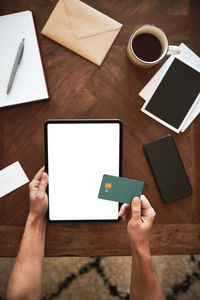 Low section of person using mobile phone on table