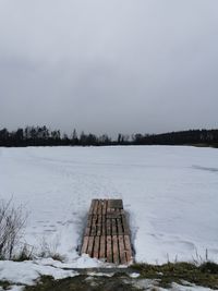 Scenic view of snow covered field against sky