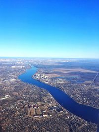 Aerial view of river and cityscape against blue sky