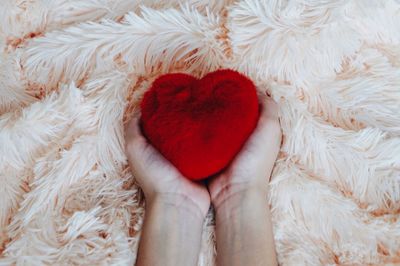 Directly above shot of woman holding red heart