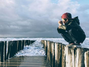 Man standing on sea shore against sky