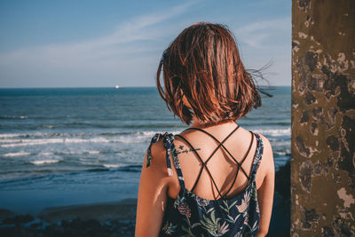 Rear view of woman looking at sea against sky