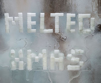 Close-up of text on wet glass window