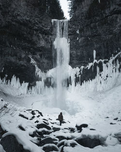 Scenic view of waterfall against trees during winter