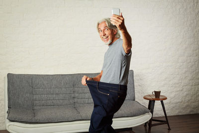 Man using mobile phone on sofa at home