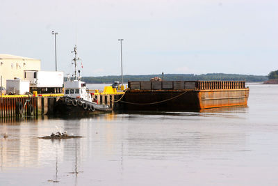 Boats moored in sea against clear sky