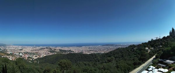 High angle view of town by sea against clear sky