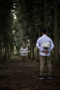 Rear view of man standing in forest