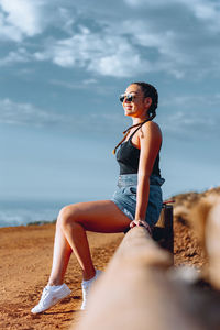 Side view of woman sitting on beach