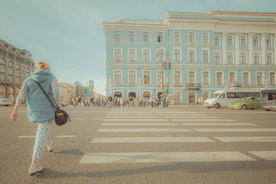 People walking on road against buildings