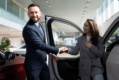 Smiling woman shaking hand with sales person