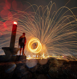 Man spinning wire wool at night