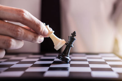 Midsection of businessman playing chess in office