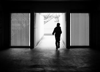 Rear view of boy walking in corridor