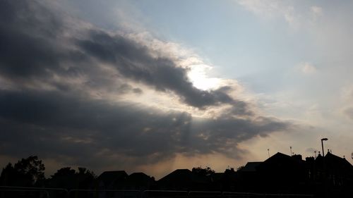 Silhouette of building against cloudy sky
