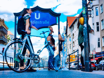 Man with bicycle on street in city