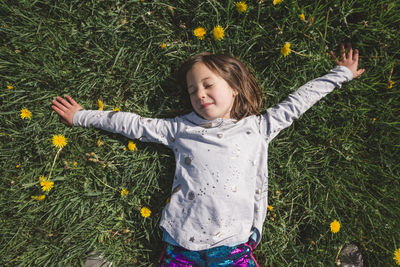 Happy girl with flowers on field