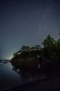 Scenic view of trees against sky at night