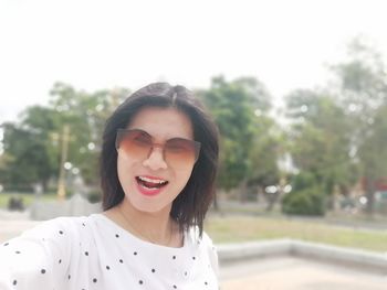 Portrait of woman wearing sunglasses while standing outdoors