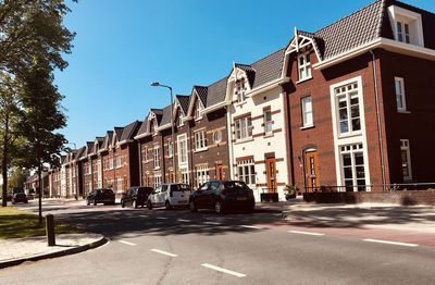 Street by buildings against sky in city