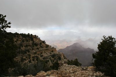 Scenic view of mountains against cloudy sky